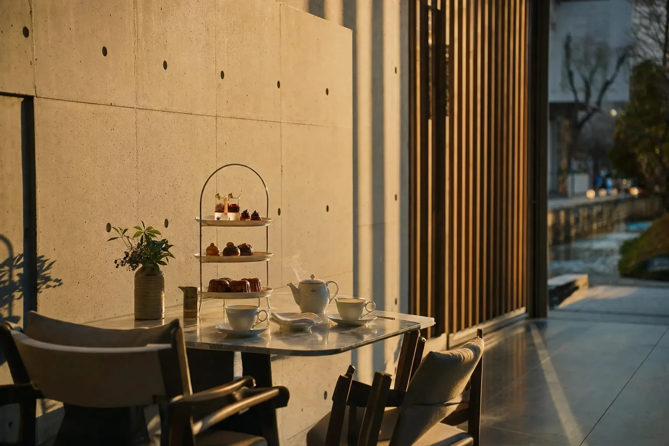 The open-air café at The Shinmonzen set for Paris-style afternoon tea with patisserie plated on a small table