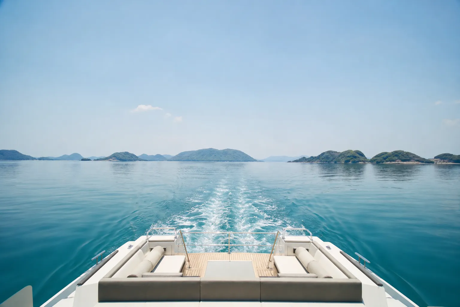 Private catamaran cruising calm water in the Seto Inland Sea with green islands on the horizon
