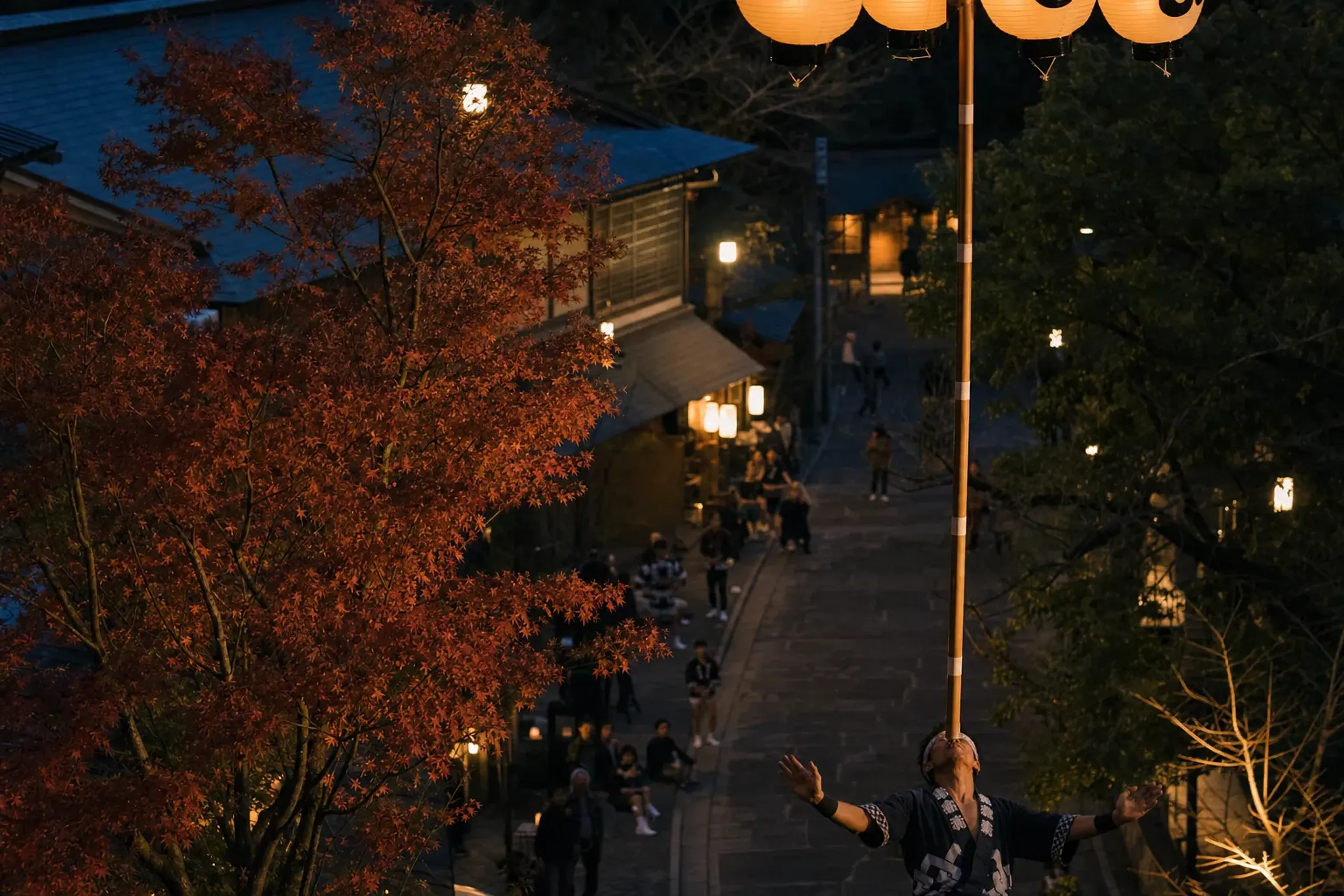 The lantern-strung 12-meter bamboo Kanto pole balanced on a performer's forehead along Kanto Street in Akita