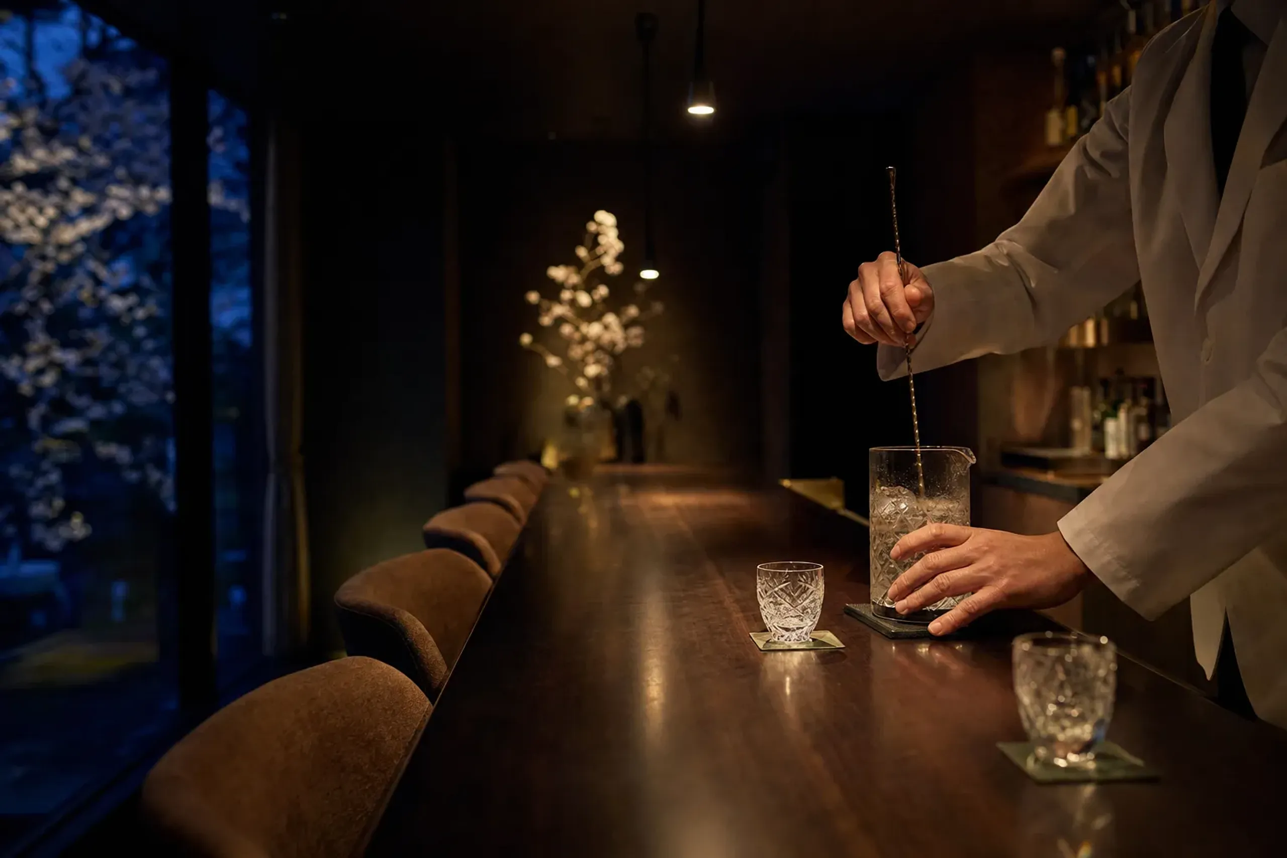 Intimate Tokyo bar with a single bartender and a small counter under warm dim light
