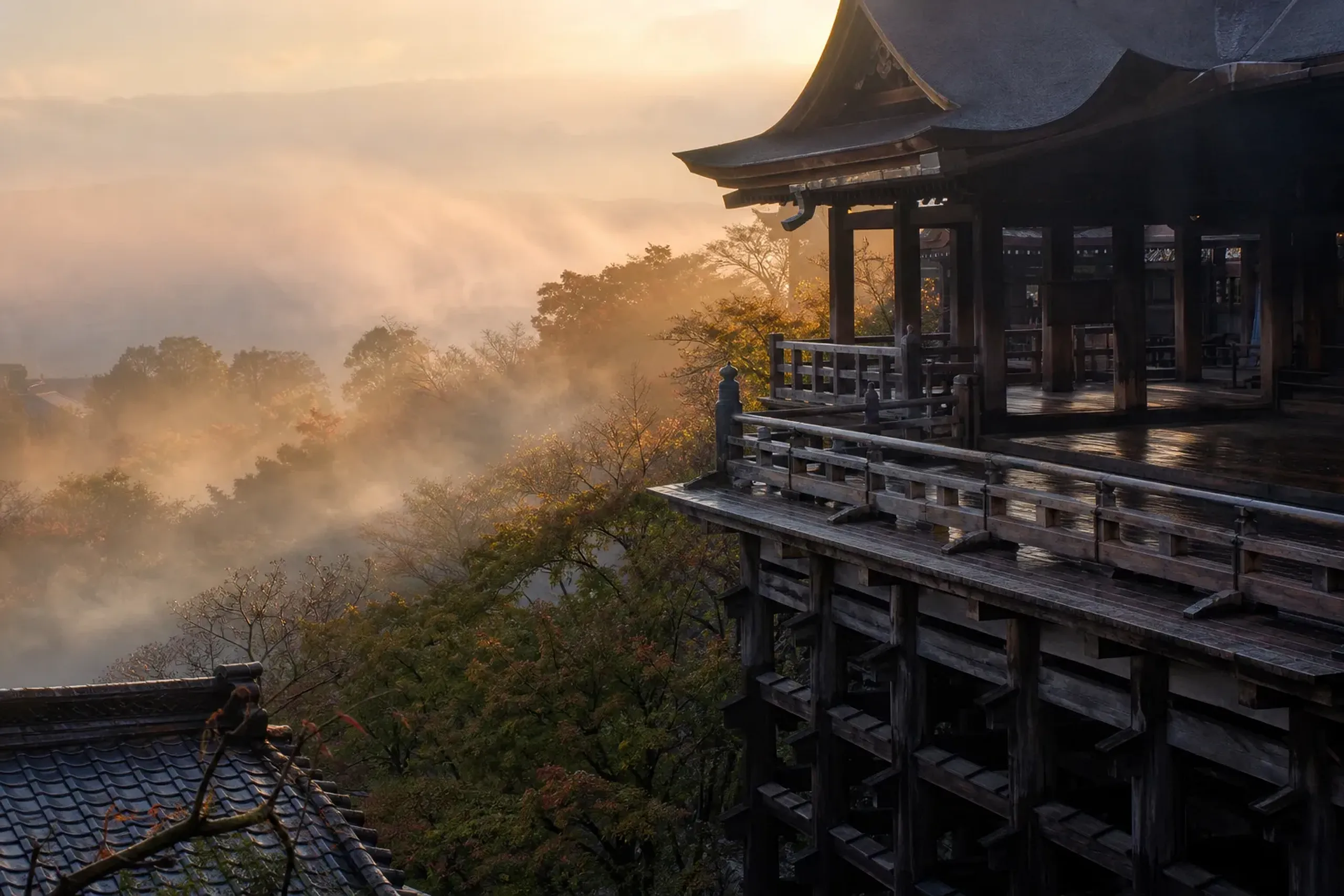 Kiyomizu-dera wooden stage above misty Kyoto at sunrise with few visitors