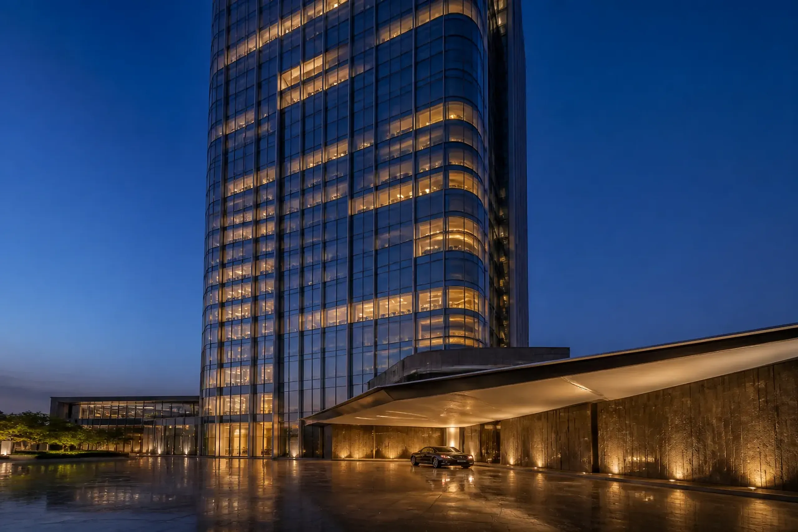 Modern glass towers and a sheltered arrival plaza in Toranomon at dusk with few pedestrians