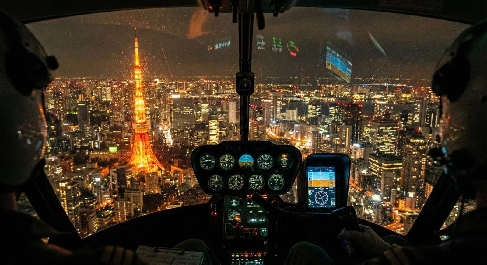 View of Tokyo Tower and city lights at night from a private luxury helicopter cruise.