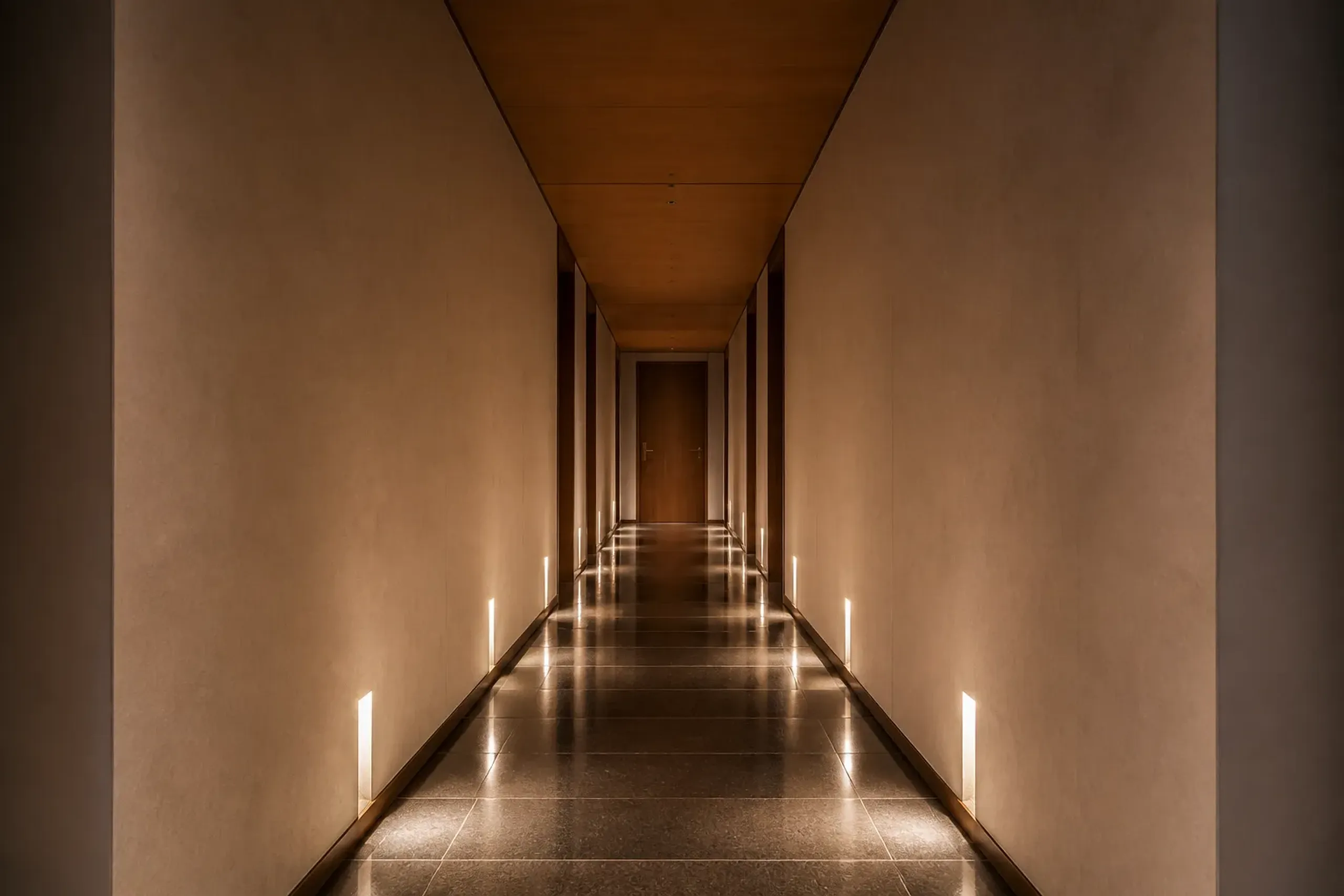 Empty minimalist luxury hotel corridor leading to a private suite in Tokyo