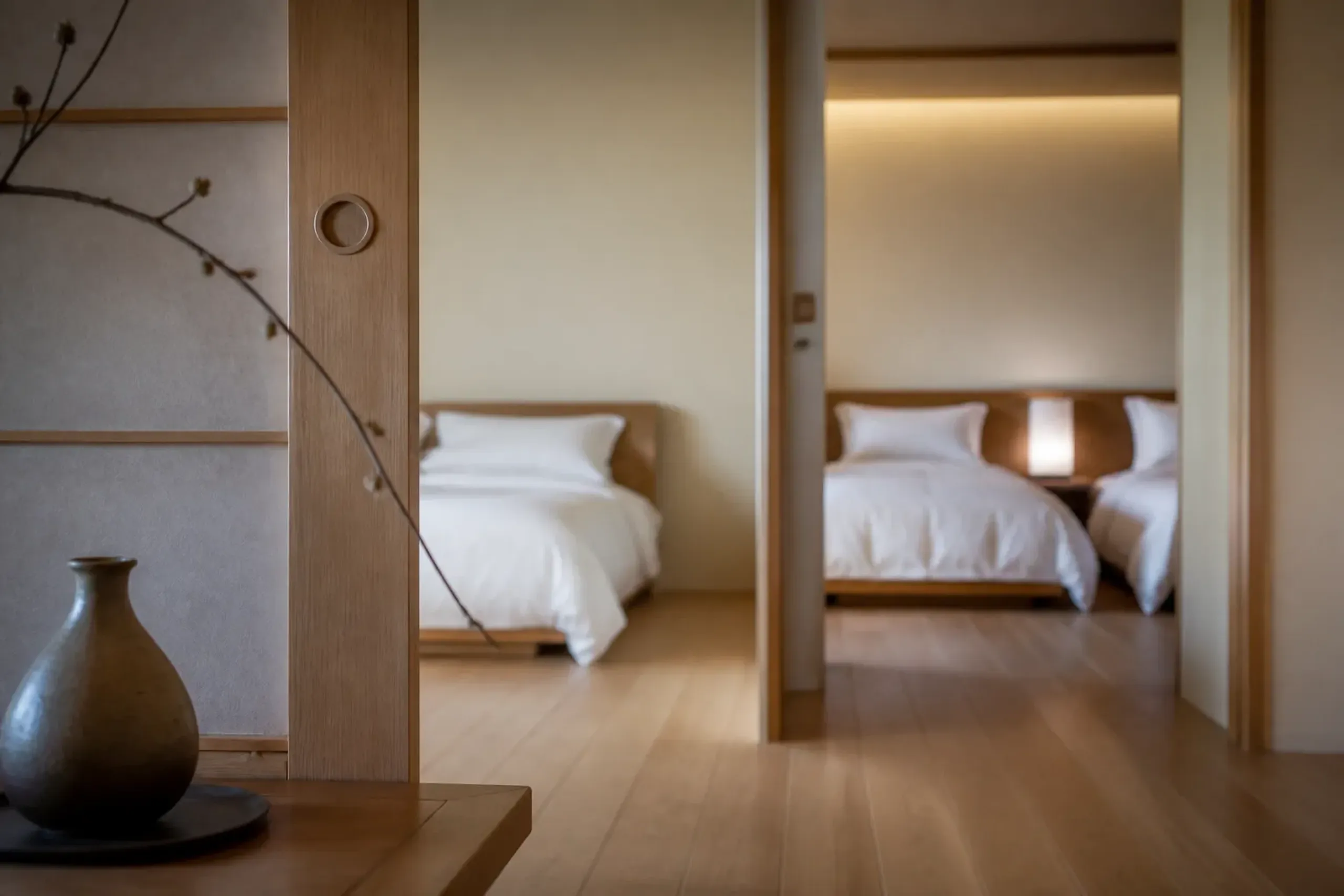 Open connecting doorway between two hotel rooms set up for a family stay in Tokyo