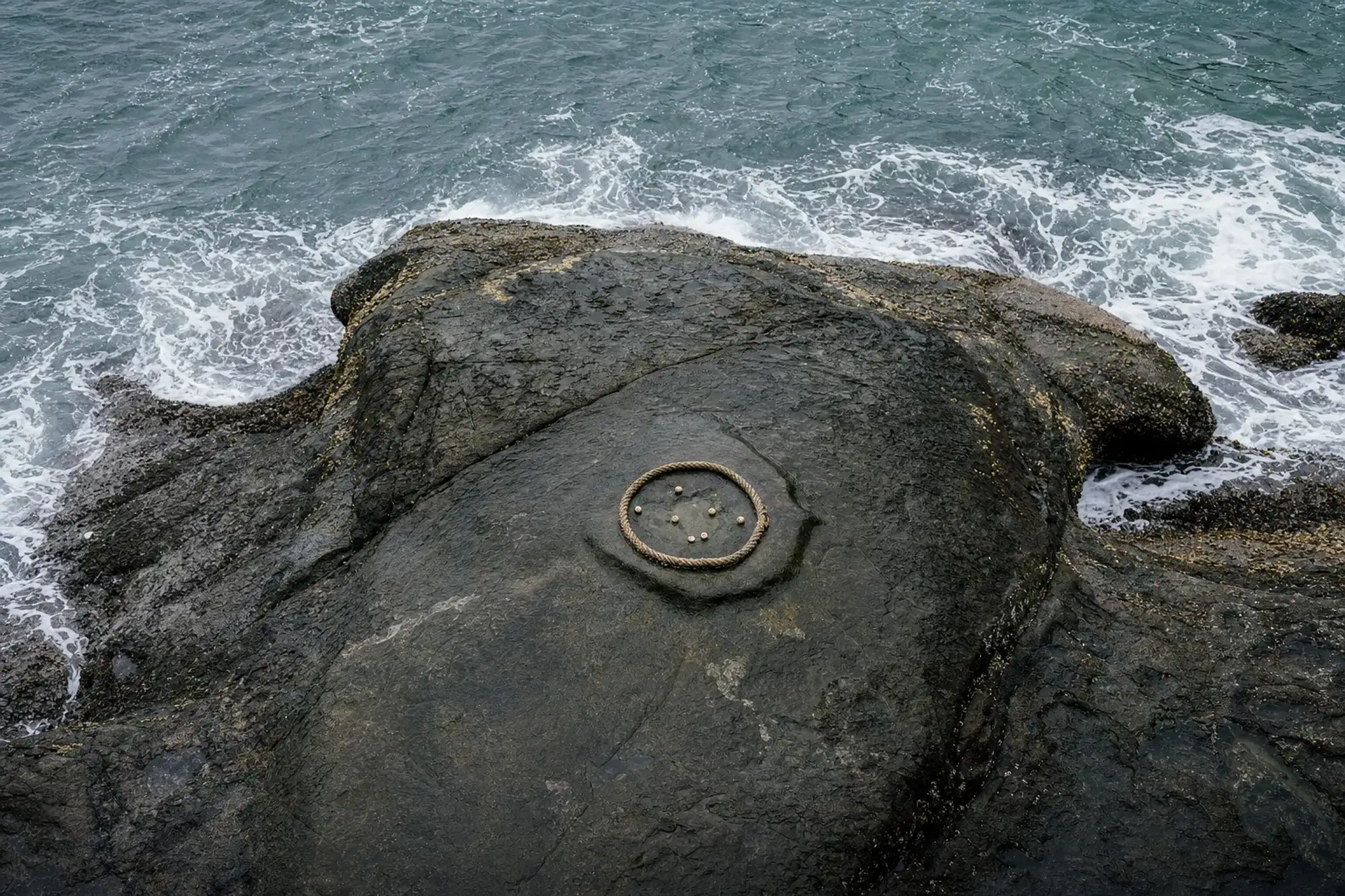 The turtle-shaped rock roughly 12 metres below the plaza, with its shallow 60-centimetre hollow in its back as the target for unda-nage balls, washed by surf