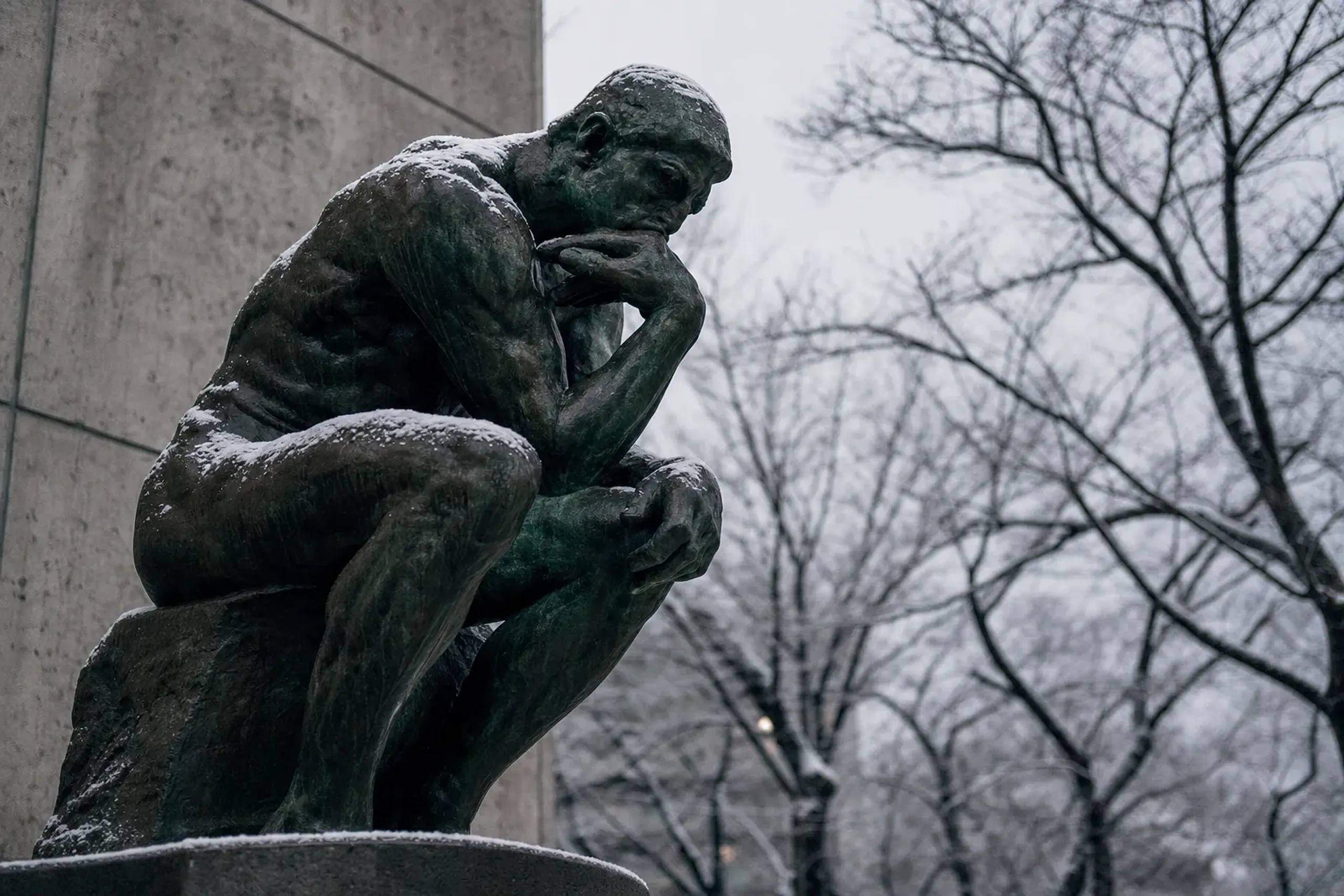 Auguste Rodin's bronze cast of The Thinker standing in the forecourt of the National Museum of Western Art, framed by the surrounding trees of Ueno Park
