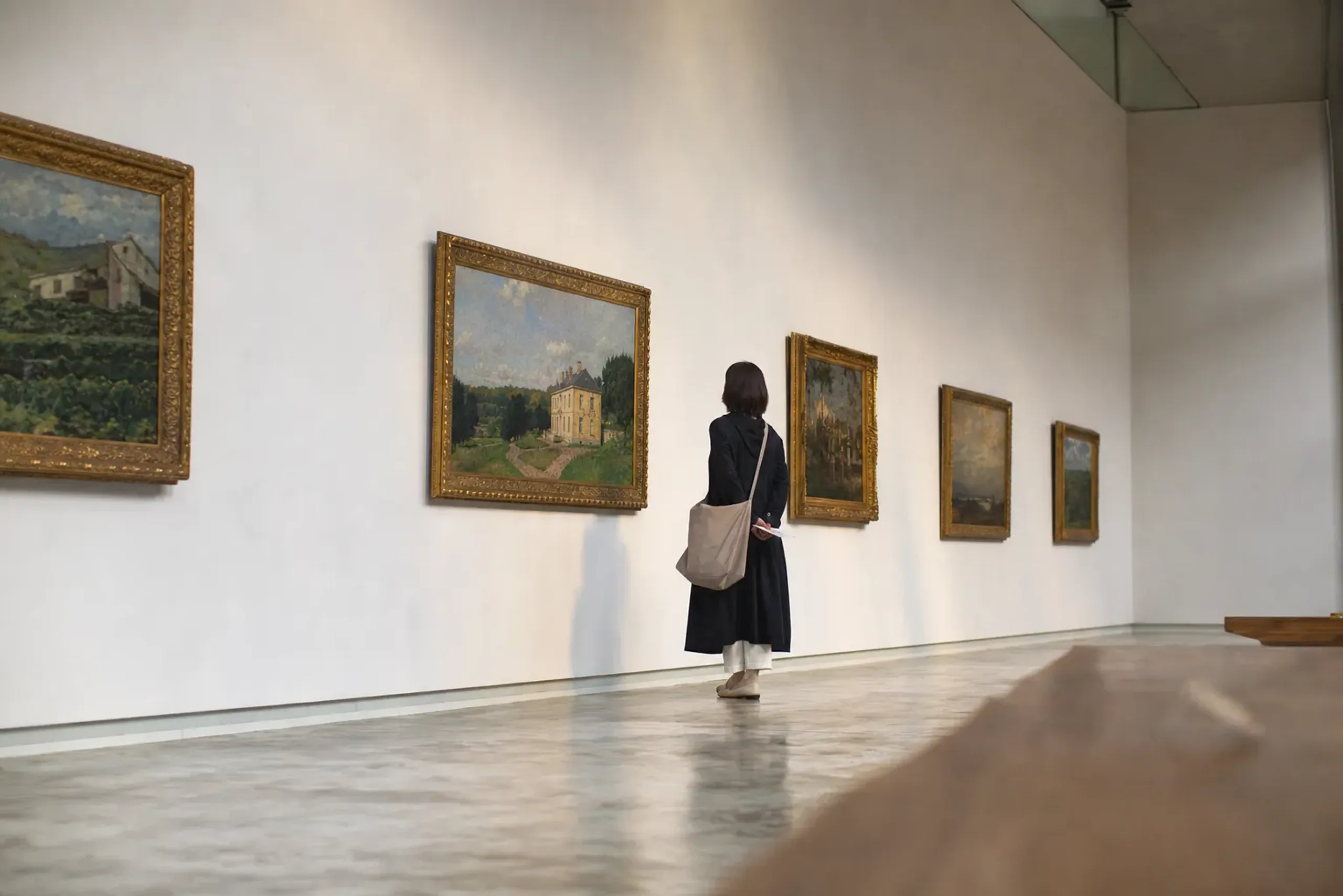 The daylit permanent-collection galleries of the National Museum of Western Art, with framed European paintings hung along a modernist white wall