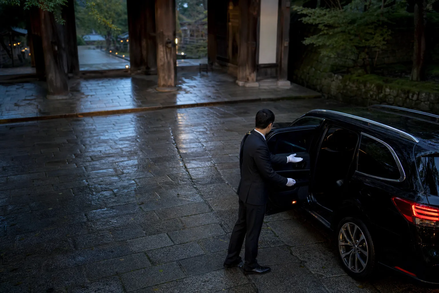 Ultimate Expression, Sophisticated Travel, professional chauffeur, English-speaking, immaculate suit, standing beside luxury SUV, respectfully opening door, Japanese temple gate background, five-star service, welcoming gesture