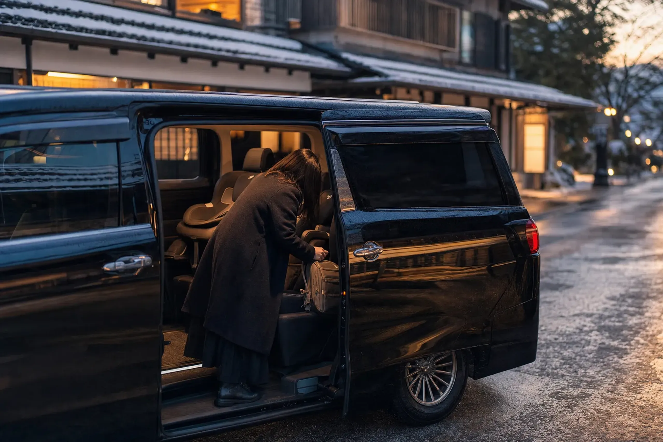 Luxury minivan waiting at curbside pickup at dusk for a family leaving a theme park
