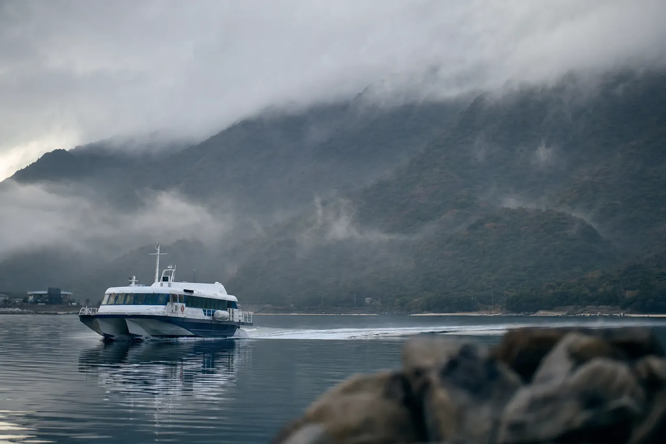 High-speed jetfoil ferry approaching Miyanoura port on the mountainous island of Yakushima