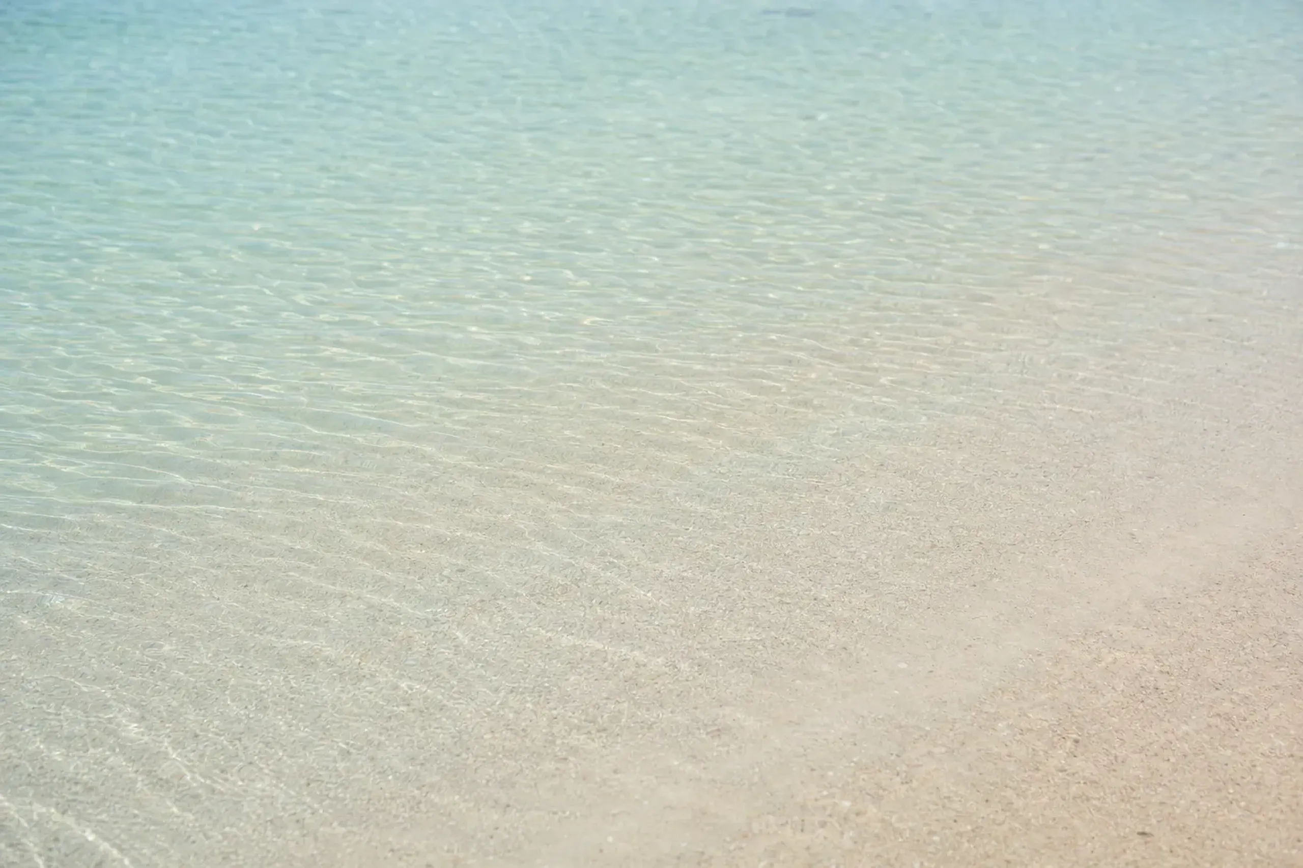 the shallow, gently sloping shoreline of Ōganeku Beach with calm clear water