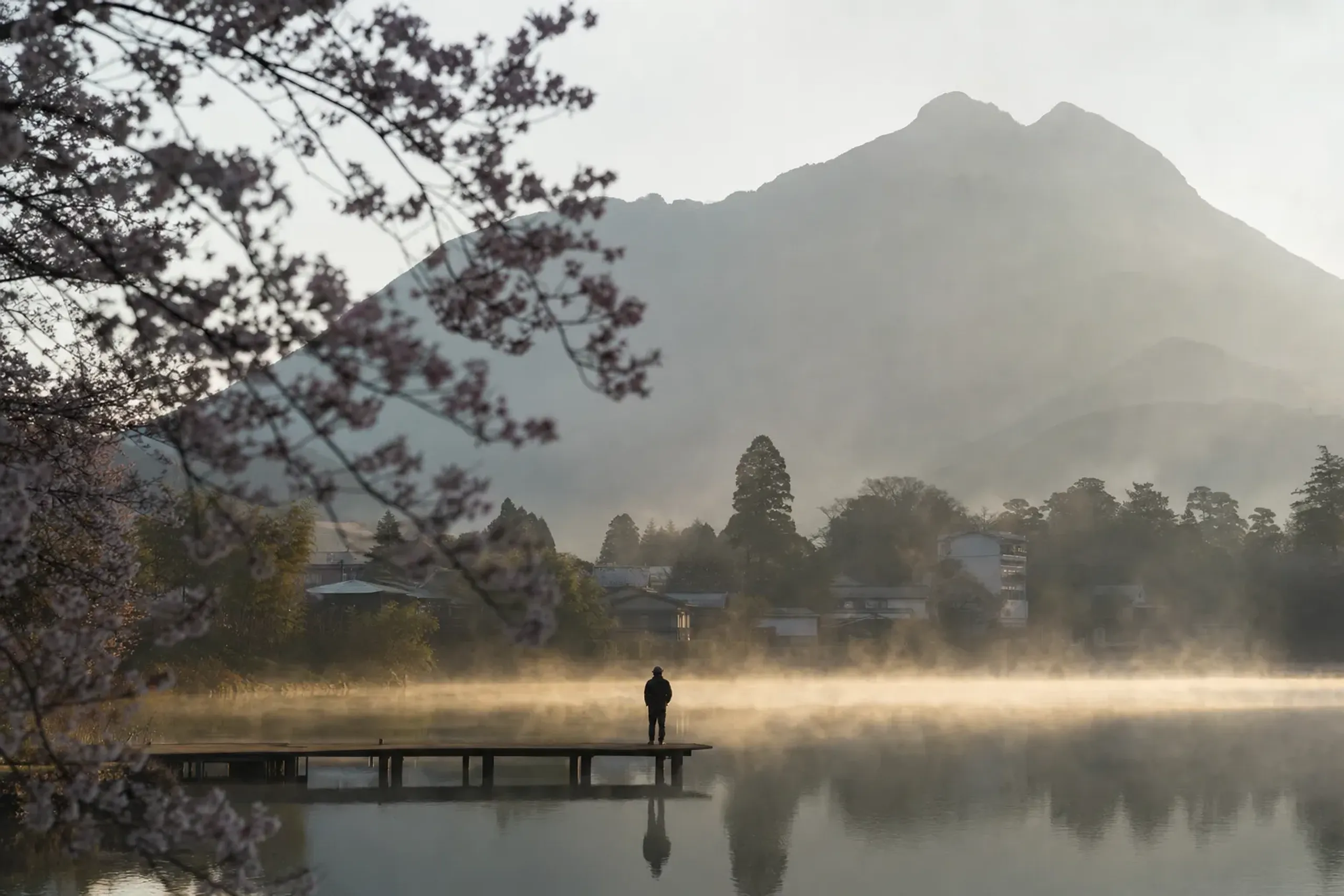 Morning mist over Lake Kinrin with Mount Yufu behind it in Yufuin