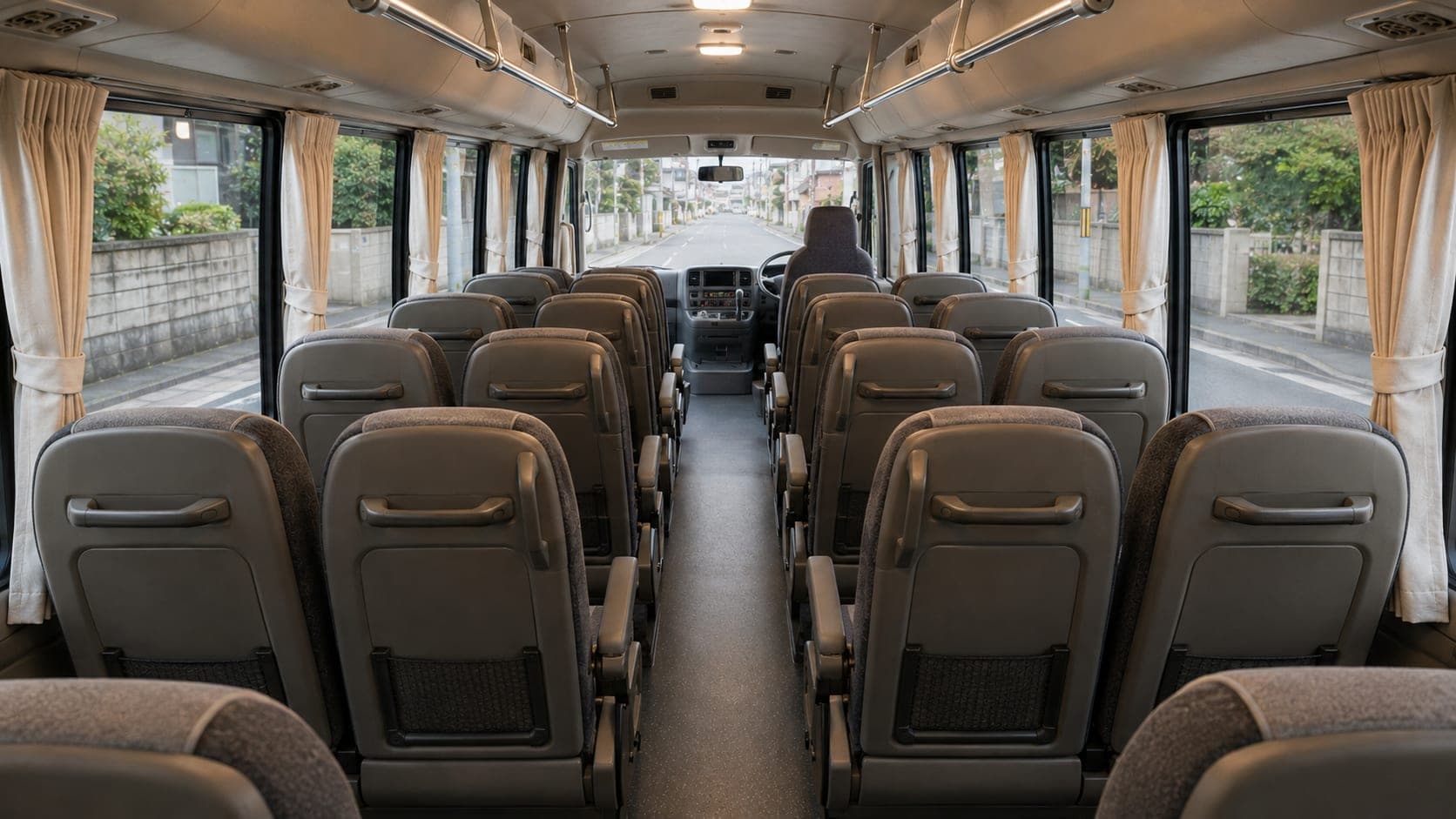 Toyota Coaster cabin with curtained windows along the centre aisle