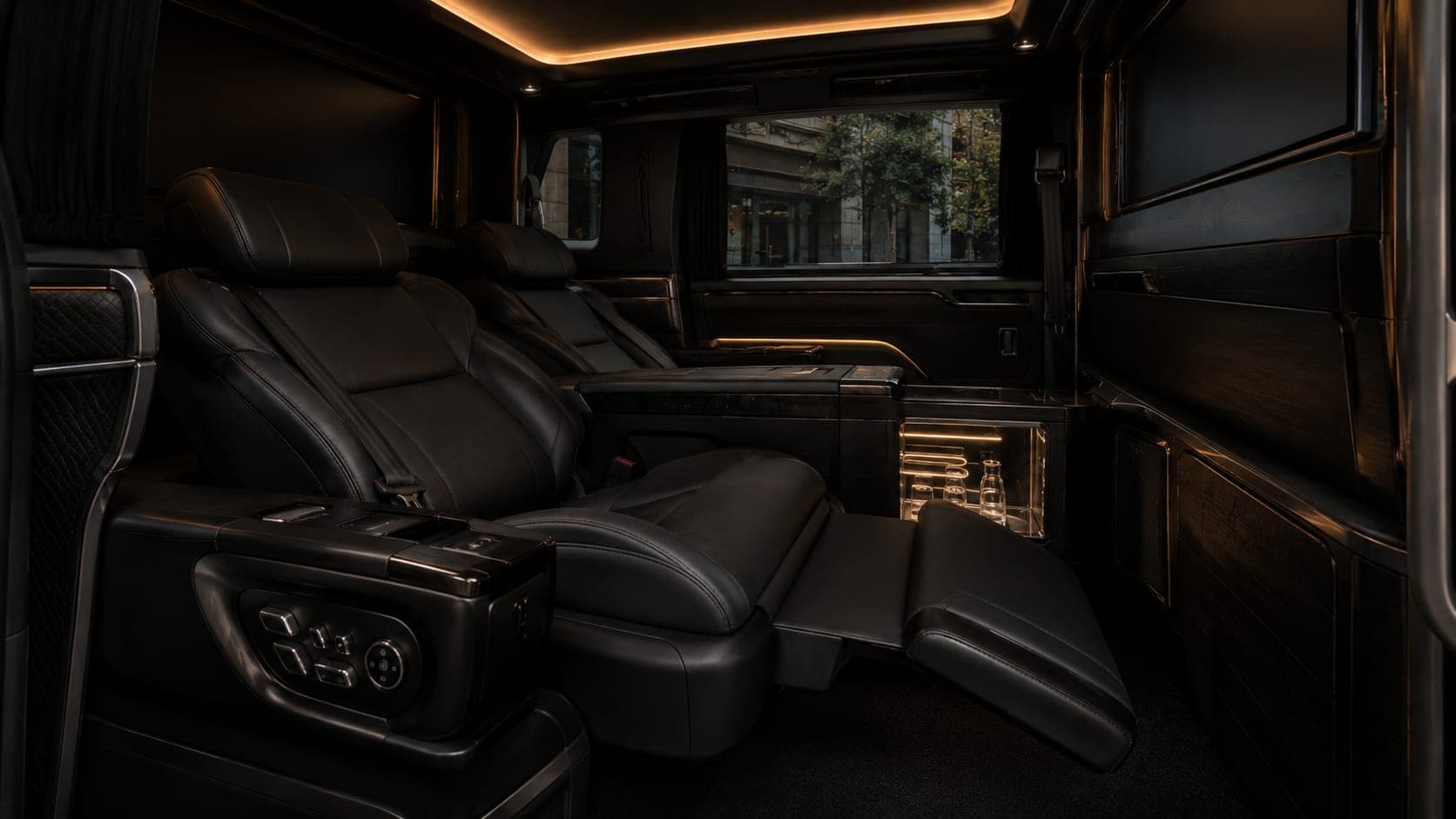 Lexus LM500h rear lounge with the seats reclined, the ottoman raised and the cool box lit