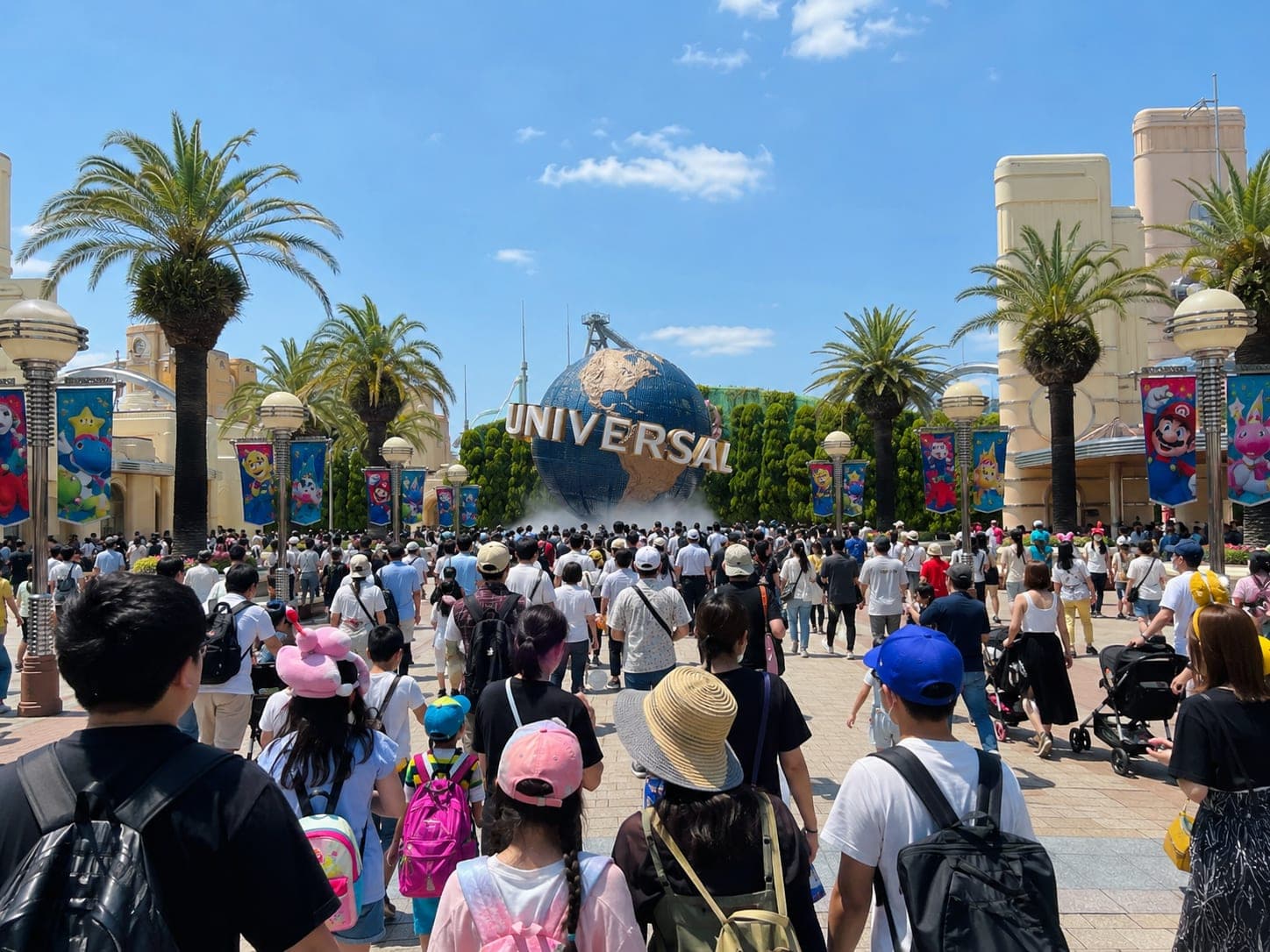 The Universal Studios Japan globe at the entrance, crowds streaming in under a bright sky