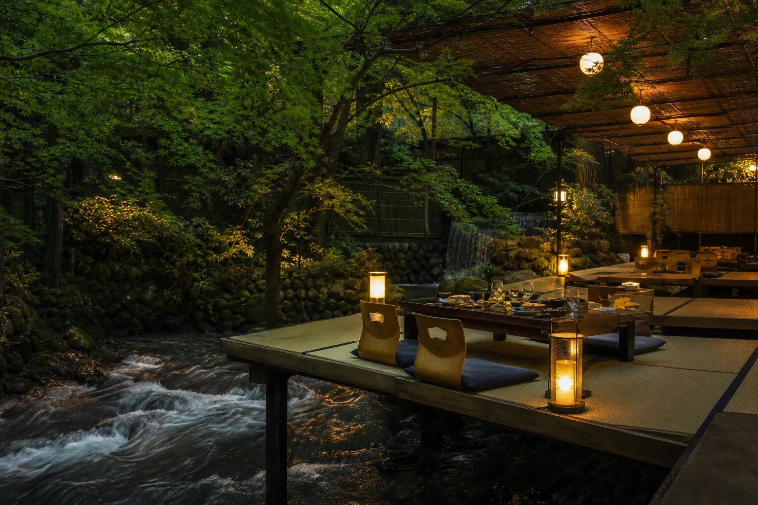 Wooden kawadoko dining platform over the Kibune River surrounded by green maples in summer