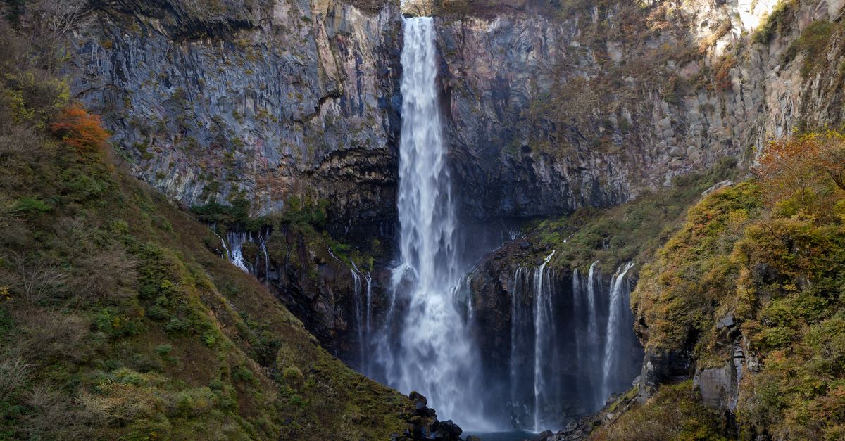 Kirifuri Falls in Nikko viewed from an observation point with forested gorge and mist