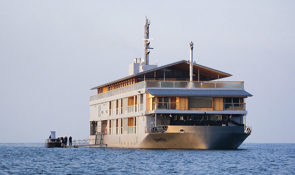The exterior of the Guntû luxury floating hotel cruising on the calm waters of the Seto Inland Sea.