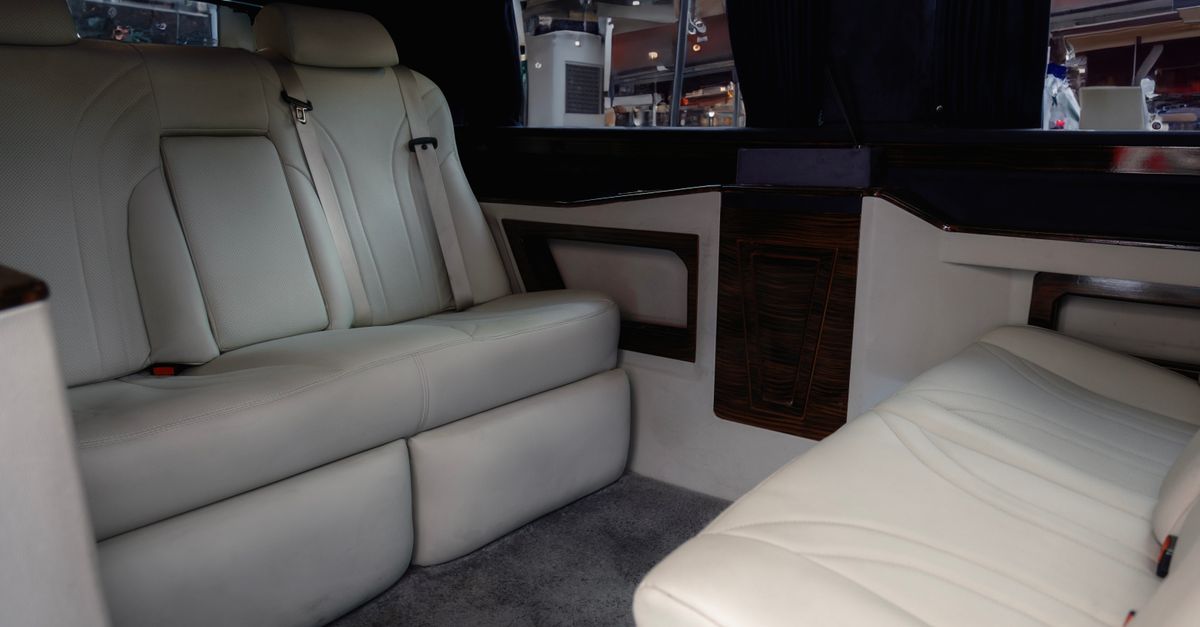 Rear cabin of a Lexus LM 500 with leather seats and bottled water prepared