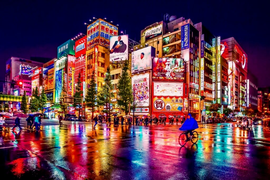 Tokyo, Japan - November 19, 2018: Neon lights and billboard advertisements on buildings at Akihabara at rainy night. Akihabara is a shopping district for video games, anime, manga, and computer goods.
