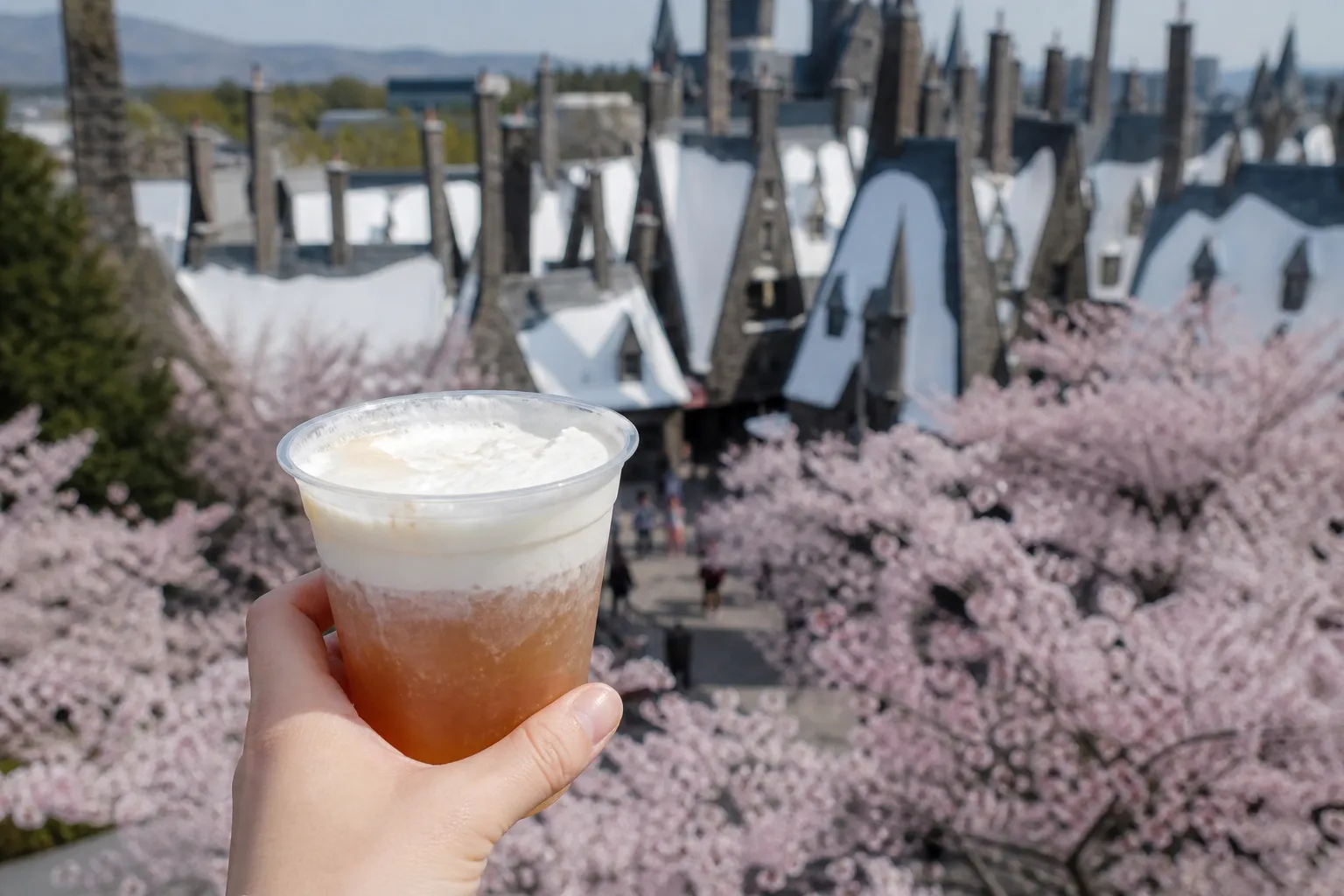 夜のホグズミードの灯りを背景に、バタービール風ドリンクを手にした様子